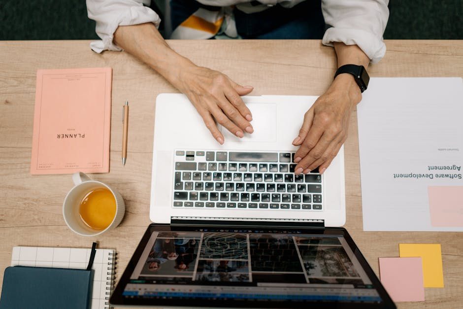 A developer writing code on a laptop, displaying programming scripts in an office environment.