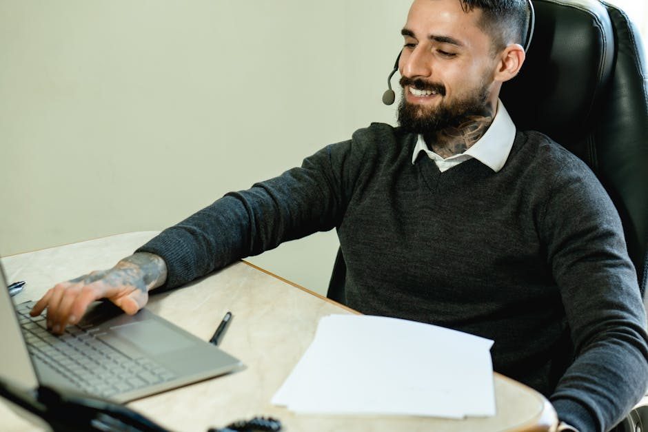 Small business team collaborating around a laptop with customer support dashboard visible.