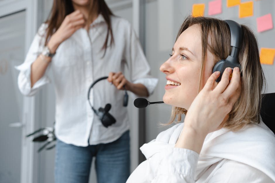 Smiling woman in headscarf working in call center on laptop with headset.
