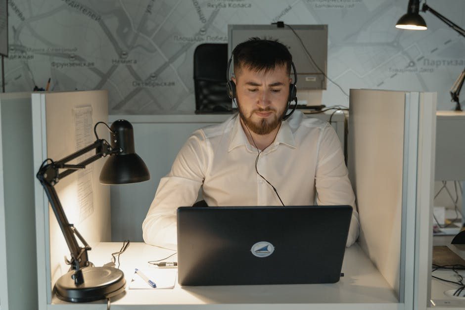 Customer support agents wearing headsets working on laptops in a modern office setting.