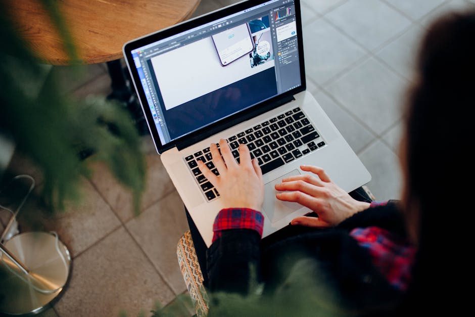 Woman working on design project using laptop at modern workspace indoors.