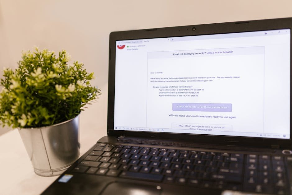 Person typing on laptop with coffee, looking focused