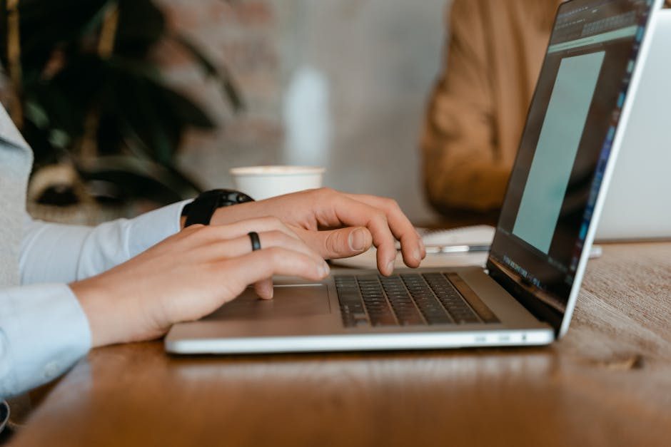 A contemporary office desk setup featuring headphones, laptops, and office essentials for a productive work environment.