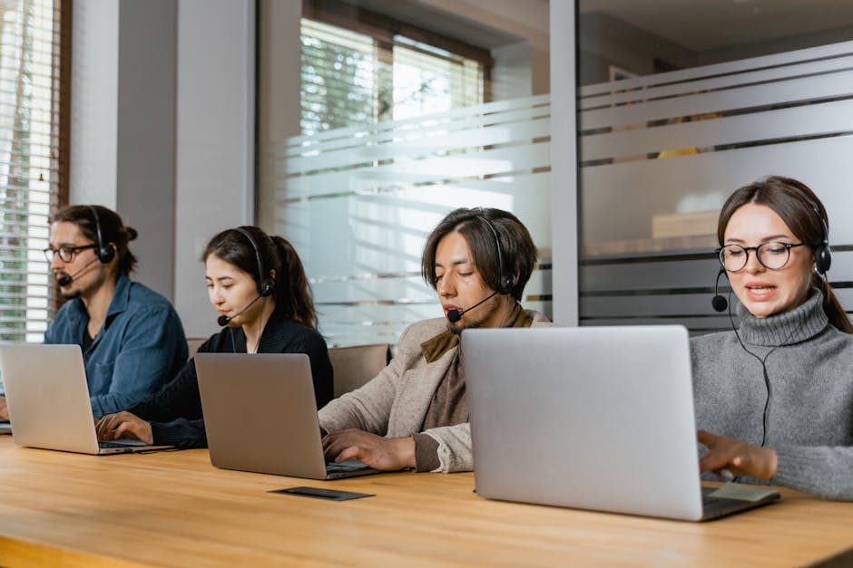 Two business professionals comparing options on laptops in a modern office.